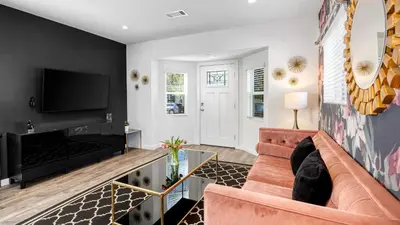 a living room with a couch and a tv at 5 Units in Heart of Hollywood Remodeled Art Deco Pink Revival by AvantStay in Los Angeles