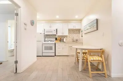 a kitchen with white appliances and a table and chairs at Walk 2 Beach, Parking, AC, WD,15min2LAX,Remodel in Manhattan Beach