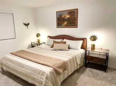 a bedroom with a large bed with two tables at Modern Desert Gem, Boho Retreat 2 Living Rooms in Hesperia