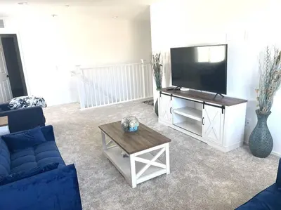 a living room with a blue couch and a flat screen tv at Modern Desert Gem, Boho Retreat 2 Living Rooms in Hesperia