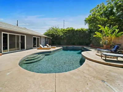 a swimming pool with chairs and a house at Retreat with Pool in Los Angeles