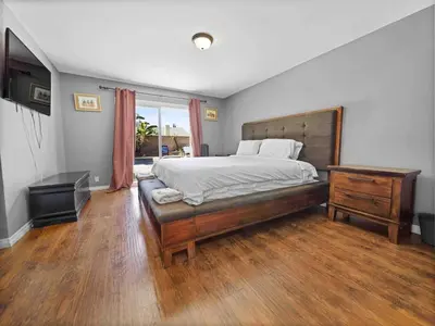 a bedroom with a large bed and a wooden floor at Retreat with Pool in Los Angeles