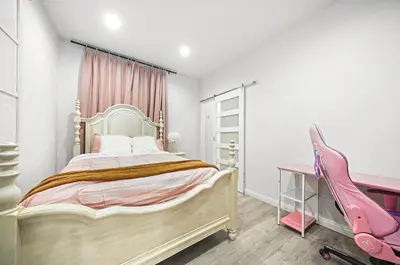 a bedroom with a large bed and a pink desk at Great Location Oasis w Huge Backyard Near DTLA ,USC ,Ktown in Los Angeles