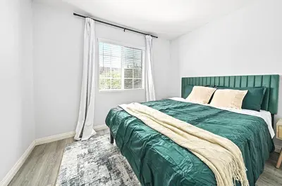 a bedroom with a green bed and a window at Great Location Oasis w Huge Backyard Near DTLA ,USC ,Ktown in Los Angeles
