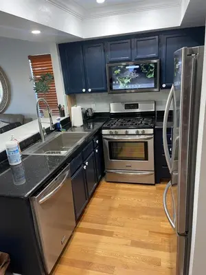 a kitchen with blue cabinets and a stainless steel appliances at Central LA GATED Community 4 beds home in Commerce