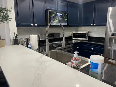 a kitchen with blue cabinets and a sink and a counter at Central LA GATED Community 4 beds home in Commerce