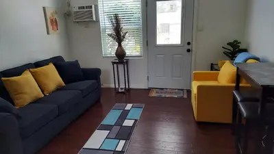 a living room with a blue couch and a yellow chair at Guestsuite in wittier in Whittier