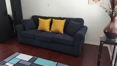 a blue couch with two yellow pillows in a living room at Guestsuite in wittier in Whittier