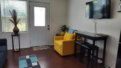 a living room with a yellow couch and a television at Guestsuite in wittier in Whittier