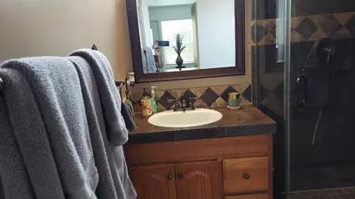 a bathroom with a sink and a shower with a mirror at Guestsuite in wittier in Whittier