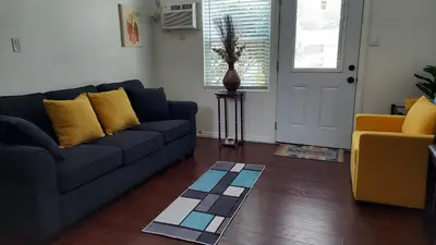 a living room with a blue couch and yellow pillows at Guestsuite in wittier in Whittier