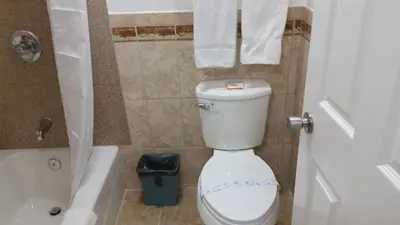 a bathroom with a toilet and a tub and a sink at Kona Inn Motel Anaheim in Anaheim