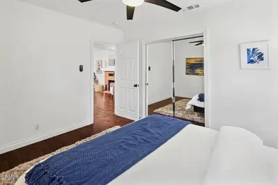 a white bedroom with a bed and a mirror at Glendale Hills Hideaway in Glendale