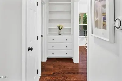 a hallway with white cabinets and a dresser with a plant at Glendale Hills Hideaway in Glendale