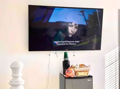 a flat screen tv on a wall with a bottle of wine at Sunrise Room 1 guest only near DTLA in San Gabriel