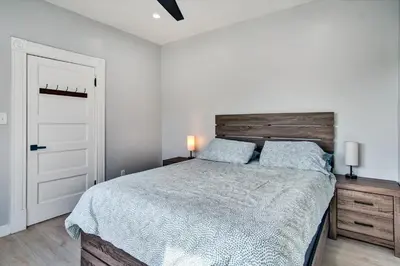 a bedroom with a large bed with a wooden headboard at Ventura Downtown Minutes to Beaches in Ventura