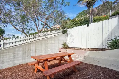 a wooden picnic table in front of a white fence at Ventura Downtown Minutes to Beaches in Ventura