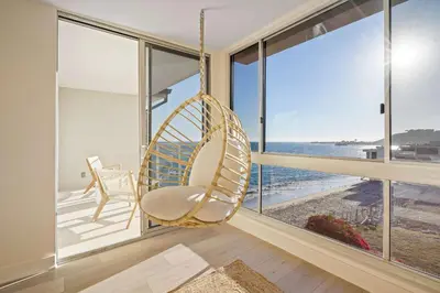 a swinging chair in a room with a view of the ocean at Aquamarine Best View in Malibu by Stay Awhile Villas in Malibu Beach