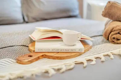 a tray with a coffee cup and books on a bed at Spacious 3BR Modern Home in LA Perfect for Family in El Monte