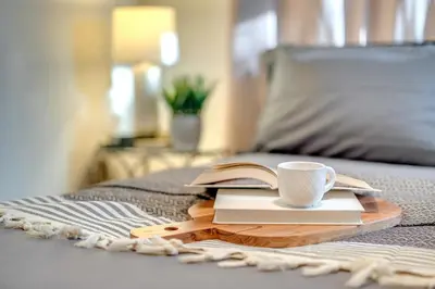 a cup of coffee and a book on a bed at Spacious 3BR Modern Home in LA Perfect for Family in El Monte