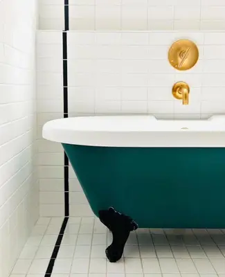 a bathroom with a blue tub and a sink at Hotel Covell in Los Angeles