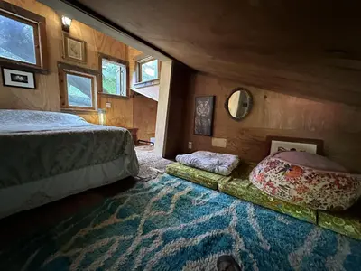 a bedroom with a bed and a large rug at Topanga Wonderland Cottage in Topanga