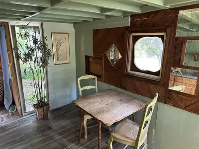 a dining room with a wooden table and a window at Topanga Wonderland Cottage in Topanga