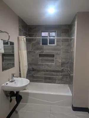 a bathroom with a tub and a sink and a shower at Star Inn Hotel in Maywood