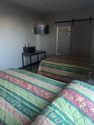 a hotel room with two beds and a table at Star Inn Hotel in Maywood