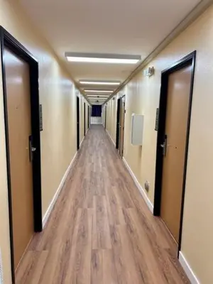 a long hallway in an office building with wooden floors at Star Inn Hotel in Maywood