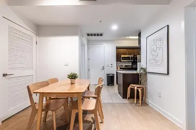 a kitchen and dining room with a wooden table and chairs at Stylish 2BDR & 2BTH - 15 mins walk to the beach! in Los Angeles