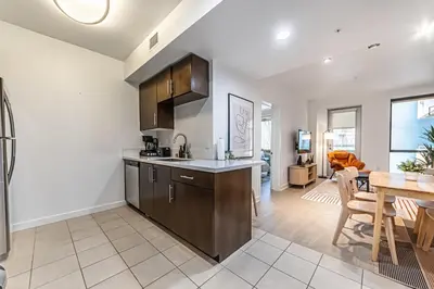 a kitchen and living room with a table and a dining room at Stylish 2BDR & 2BTH - 15 mins walk to the beach! in Los Angeles