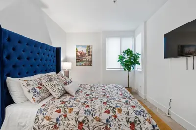 a bedroom with a large bed with a blue headboard at 15 City View Santa Monica in Los Angeles