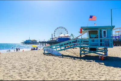 a life guard station on a beach with a roller coaster at 15 City View Santa Monica in Los Angeles
