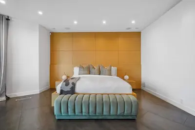 a bedroom with a bed with a wooden headboard at The Elvis Villa by Stay Awhile Villas in Los Angeles