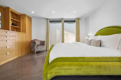 a bedroom with a large bed and a chair at The Elvis Villa by Stay Awhile Villas in Los Angeles