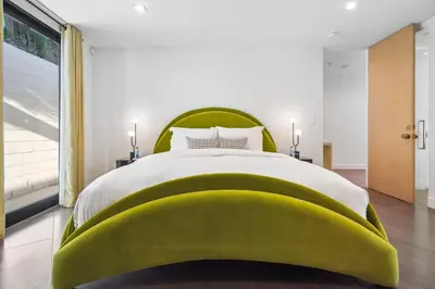 a bedroom with a green headboard and a large bed at The Elvis Villa by Stay Awhile Villas in Los Angeles