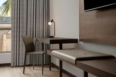 a desk and chair in a room with a window at AC Hotel by Marriott Pasadena in Pasadena