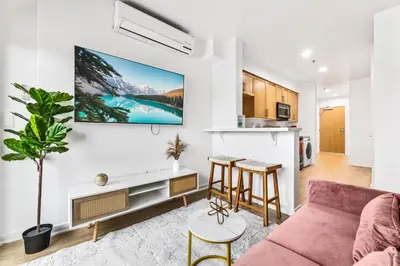 a living room with a couch and a tv on the wall at Amazing studio in SM Promenade! Free parking! in Los Angeles