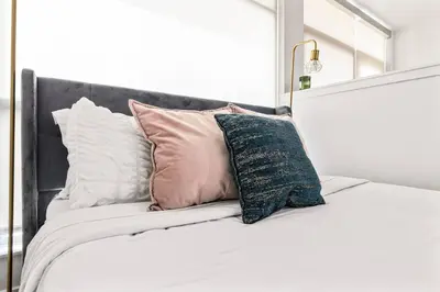 a bed with pillows on it with a mirror at Amazing studio in SM Promenade! Free parking! in Los Angeles