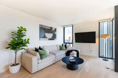 a white living room with a couch and a table at The Pearl Coast - Rooftop Pool, Gym Luxurious 2BR Santa Monica in Los Angeles