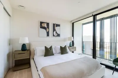 a white bedroom with a bed and a large window at The Pearl Coast - Rooftop Pool, Gym Luxurious 2BR Santa Monica in Los Angeles