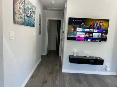 a living room with a flat screen tv on a wall at Adorable 2BR-2BA House with EV & Free Parking and Family Friendly in Los Angeles in Los Angeles