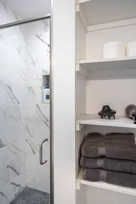 a bathroom with a glass shower door with towels at Adorable 2BR-2BA House with EV & Free Parking and Family Friendly in Los Angeles in Los Angeles