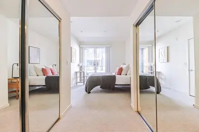 a mirror in a room with a bed and a couch at Spacious 2BD 2BA with Huge Balcony, Near Venice Beach & Fun! in Marina del Rey