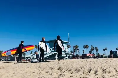 a group of men standing on the beach holding surfboards at Well-Located 3BR Near SoFi Stadium & LAX in Los Angeles