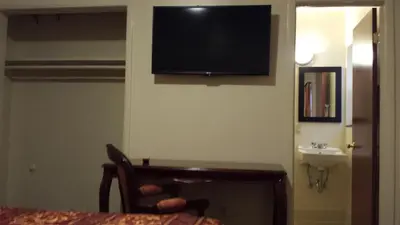 a room with a tv on the corner of a wall at Lido Hotel in Huntington Park
