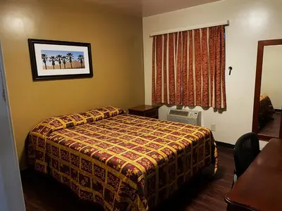 a hotel room with a bed and a window at Lido Hotel in Huntington Park