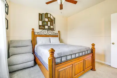 a bedroom with a wooden bed and a chair at Family-Friendly Home with Fenced Yard in Victorville in Victorville