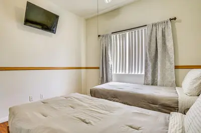 a bedroom with a bed and a window and a chair at Family-Friendly Home with Fenced Yard in Victorville in Victorville